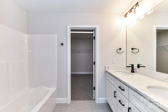 bathroom with vanity and a bath