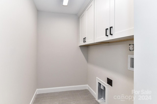 laundry area with hookup for an electric dryer and cabinets