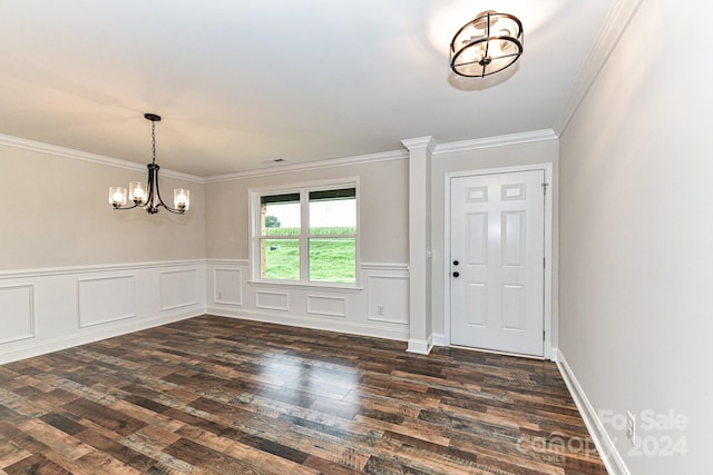 entryway featuring crown molding, dark wood-type flooring, and an inviting chandelier