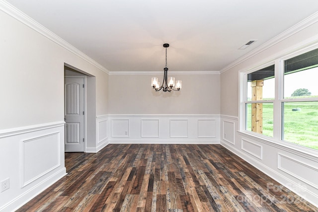 unfurnished room with dark hardwood / wood-style floors, ornamental molding, and an inviting chandelier