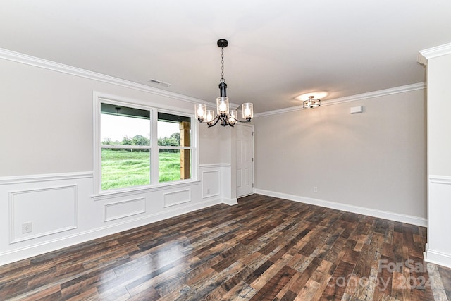 spare room with a chandelier, dark hardwood / wood-style floors, and ornamental molding