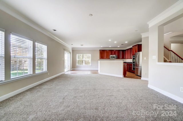 unfurnished living room featuring light colored carpet and crown molding