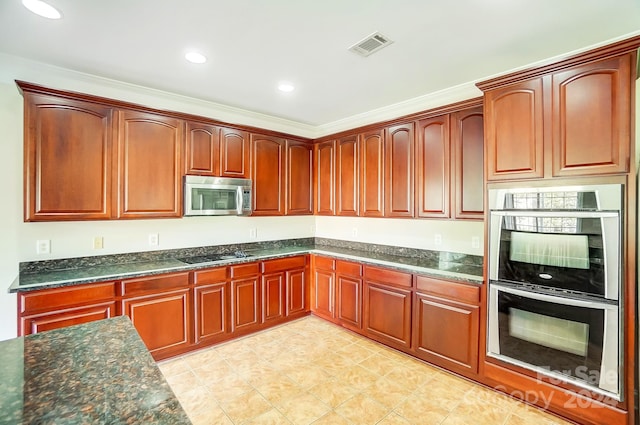 kitchen featuring stainless steel appliances, crown molding, and dark stone countertops