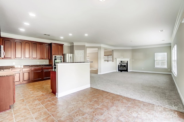 kitchen with crown molding, light colored carpet, a fireplace, and appliances with stainless steel finishes