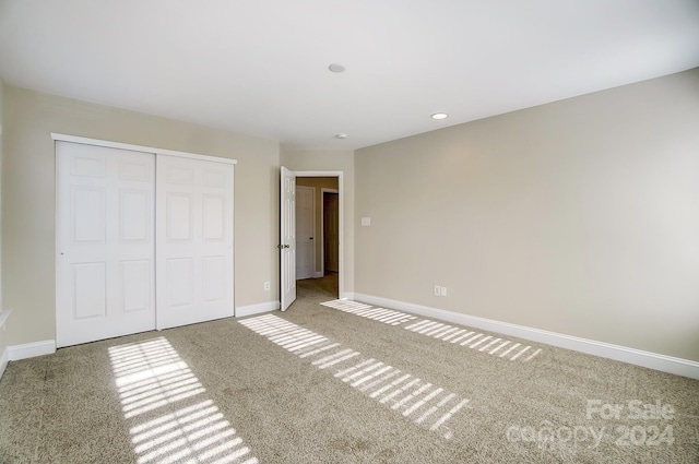 unfurnished bedroom featuring carpet flooring and a closet