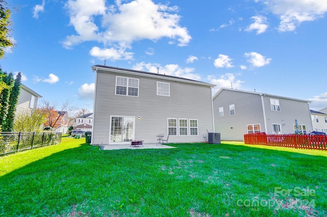 rear view of house featuring a lawn, cooling unit, a patio, and an outdoor fire pit