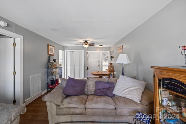 living room with ceiling fan and dark wood-type flooring