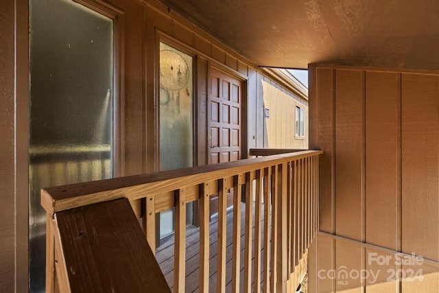 hallway featuring wood walls