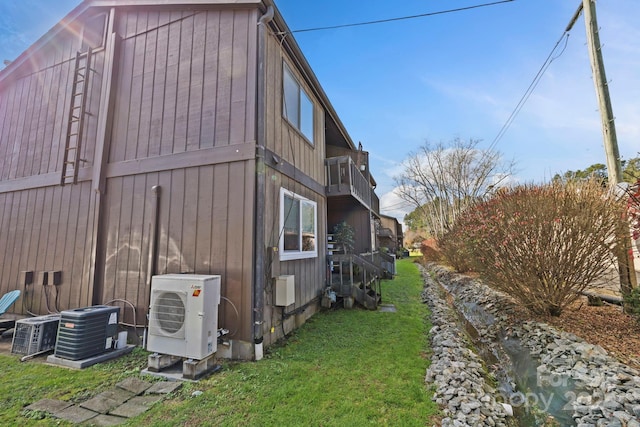 view of home's exterior with ac unit, a yard, and central AC