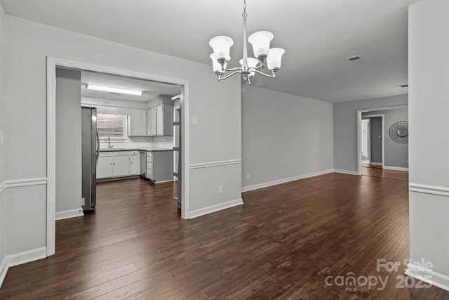 interior space featuring dark wood-type flooring, sink, and an inviting chandelier