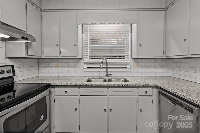 kitchen featuring tasteful backsplash, white cabinets, appliances with stainless steel finishes, and sink