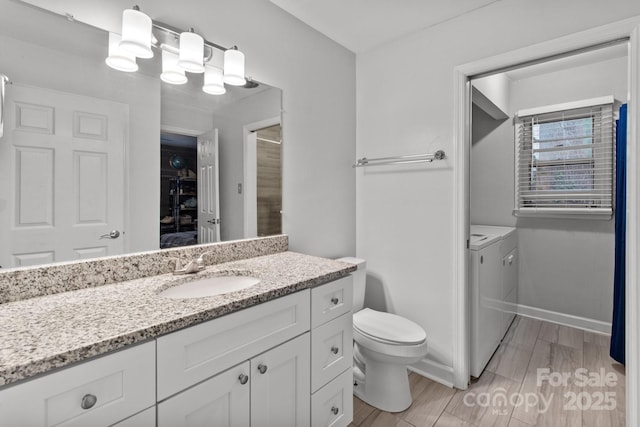 bathroom featuring toilet, vanity, and independent washer and dryer