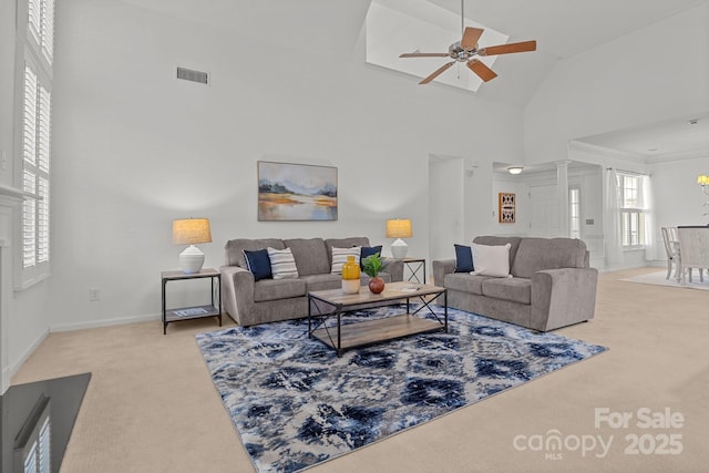 living room featuring ceiling fan, light carpet, and a high ceiling