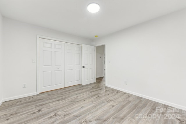 unfurnished bedroom with a closet and light hardwood / wood-style floors