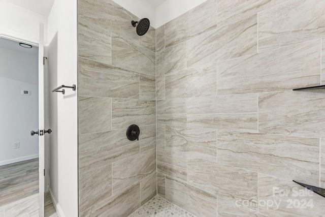 bathroom featuring tiled shower and hardwood / wood-style flooring