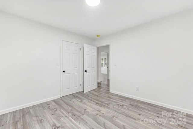 unfurnished bedroom featuring light hardwood / wood-style floors and a closet