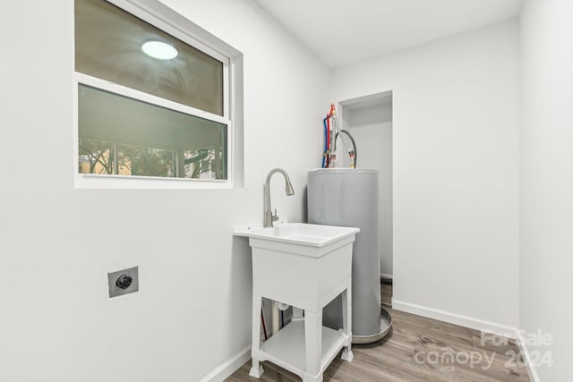 laundry area featuring hookup for an electric dryer, gas water heater, and hardwood / wood-style floors