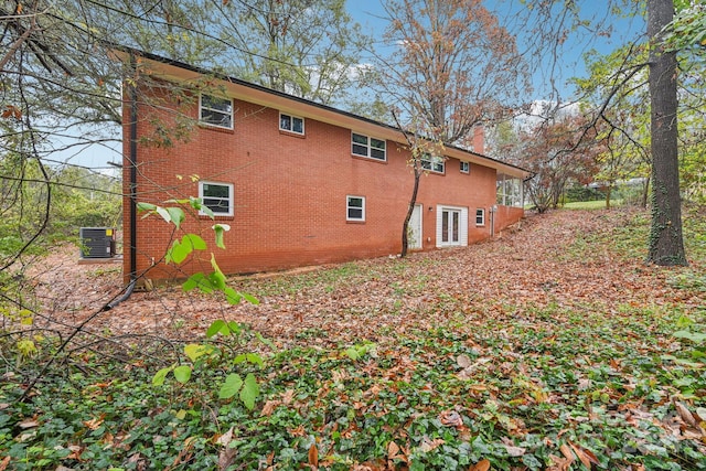 back of house with central AC unit