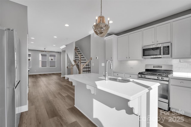 kitchen featuring a sink, backsplash, light countertops, and appliances with stainless steel finishes