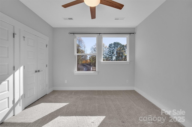 unfurnished bedroom featuring visible vents, baseboards, carpet flooring, and a closet