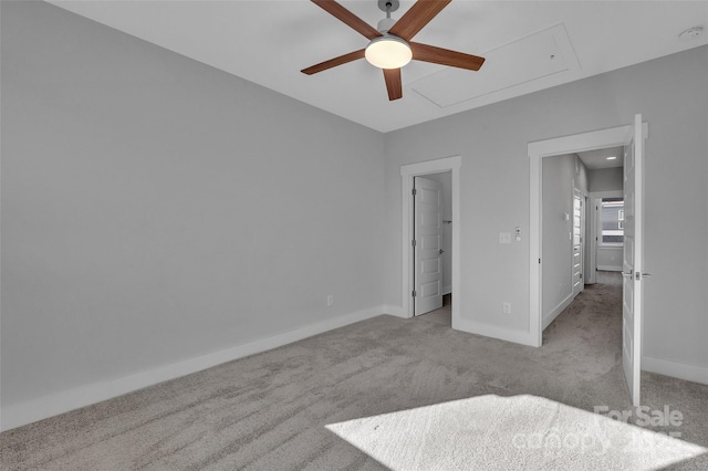 unfurnished bedroom with carpet flooring, baseboards, a ceiling fan, and attic access
