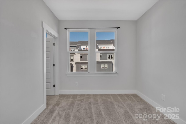empty room featuring carpet floors and baseboards