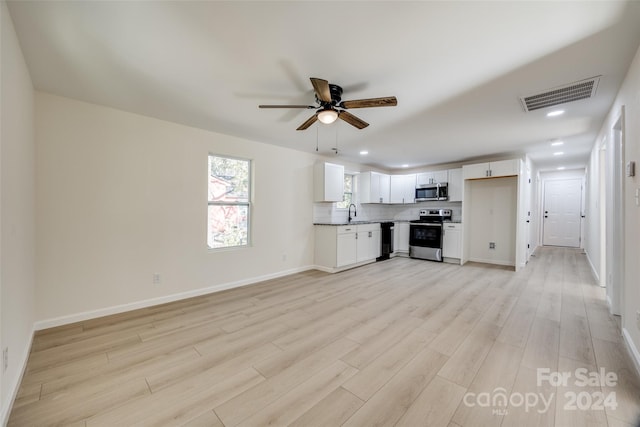 unfurnished living room with ceiling fan and light wood-type flooring