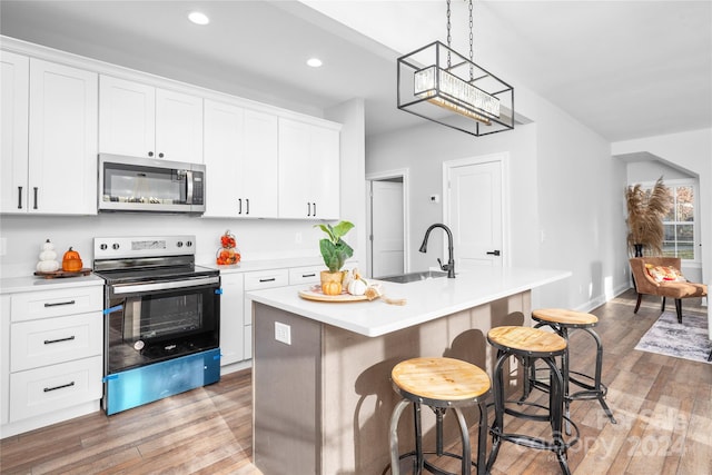 kitchen with white cabinets, an island with sink, and appliances with stainless steel finishes