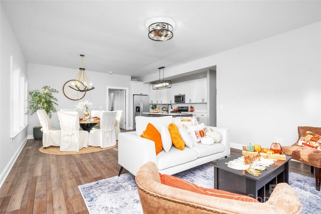 living room featuring sink, a chandelier, and hardwood / wood-style flooring