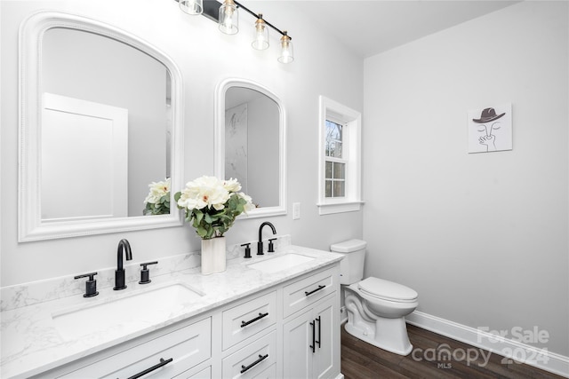 bathroom with hardwood / wood-style flooring, vanity, and toilet