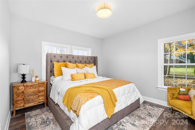 bedroom with dark wood-type flooring and multiple windows