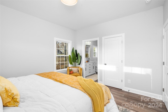 bedroom featuring dark hardwood / wood-style floors and ensuite bath