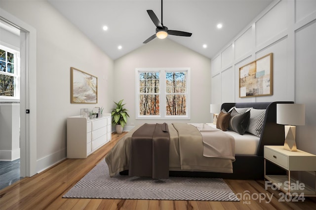 bedroom with light wood-type flooring, vaulted ceiling, multiple windows, and ceiling fan