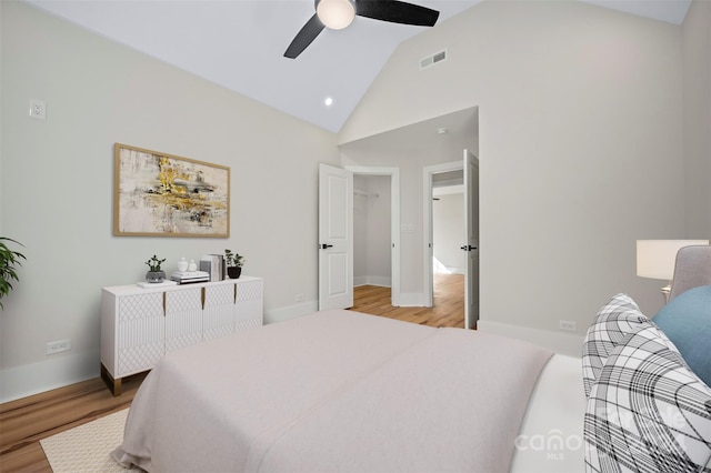 bedroom with ceiling fan, high vaulted ceiling, and light hardwood / wood-style flooring