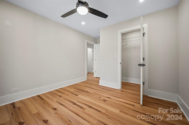 unfurnished bedroom with ceiling fan, a closet, and light wood-type flooring