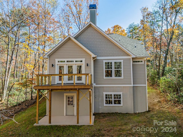 back of house featuring a deck, a patio, and a yard