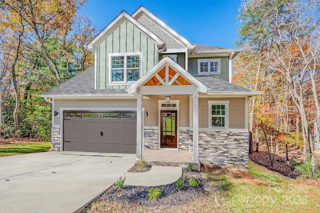 craftsman inspired home featuring stone siding, a garage, board and batten siding, and driveway