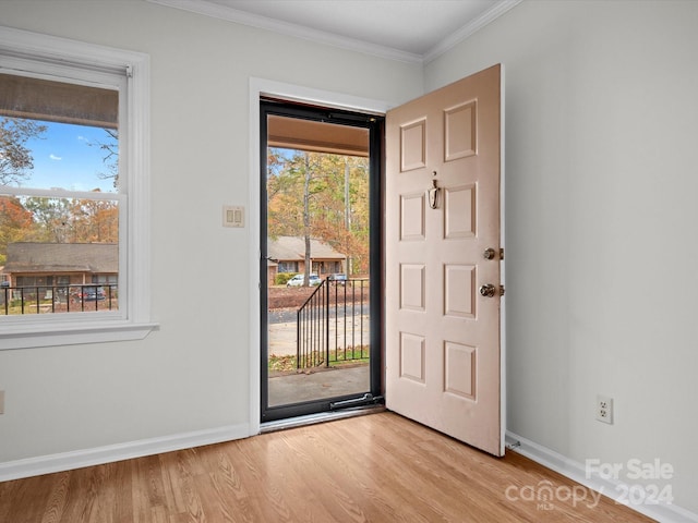 entrance foyer featuring crown molding and light hardwood / wood-style flooring