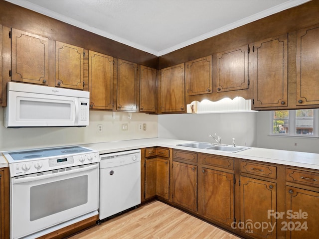 kitchen with light hardwood / wood-style floors, white appliances, sink, and ornamental molding