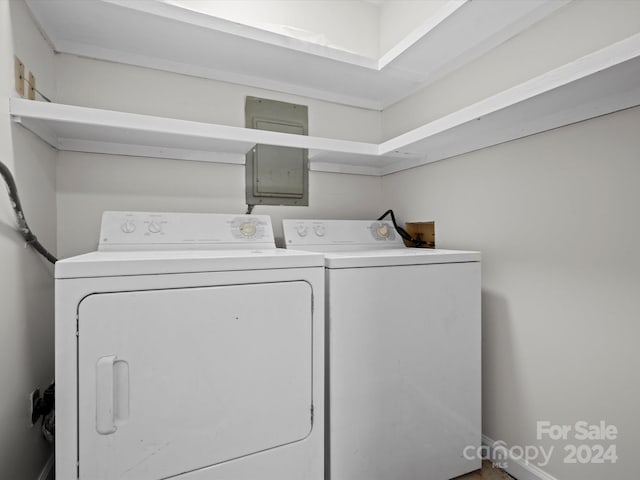 clothes washing area featuring electric panel and separate washer and dryer