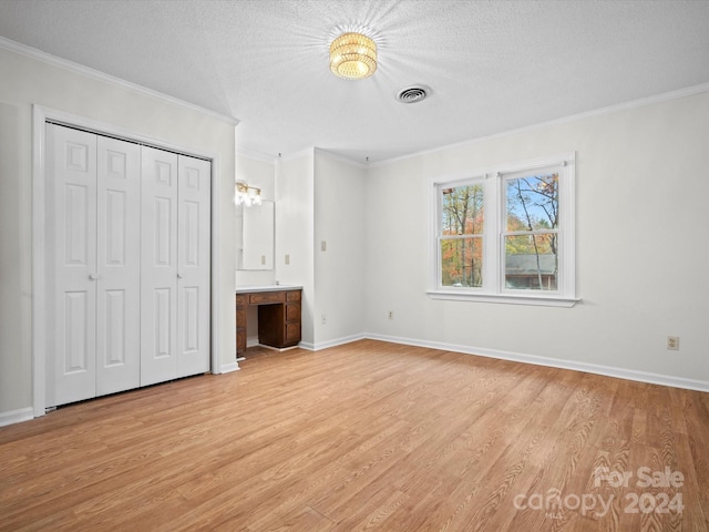 unfurnished bedroom featuring crown molding, a textured ceiling, and light wood-type flooring