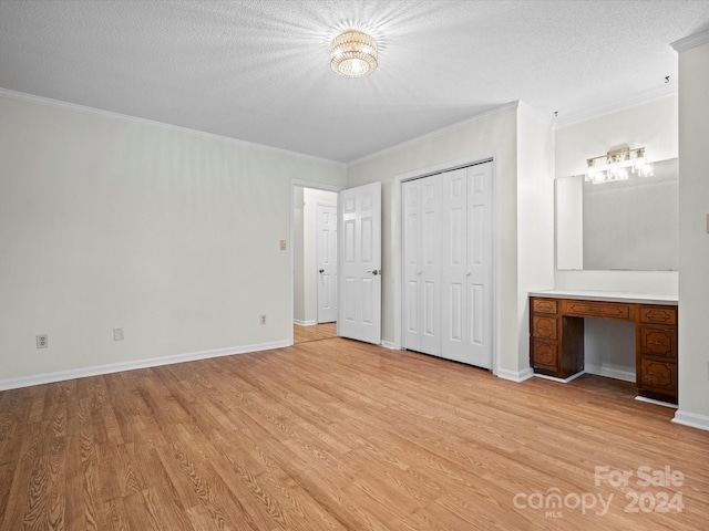 unfurnished bedroom featuring ornamental molding, a textured ceiling, and light wood-type flooring