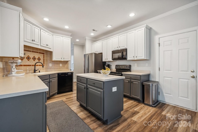 kitchen with gray cabinetry, a kitchen island, hardwood / wood-style floors, white cabinets, and black appliances