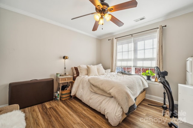 bedroom featuring ceiling fan, crown molding, and wood-type flooring