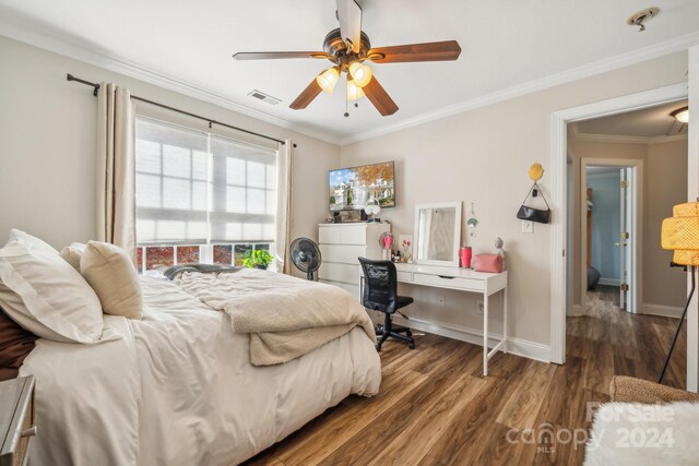 bedroom featuring ceiling fan, dark hardwood / wood-style floors, and ornamental molding