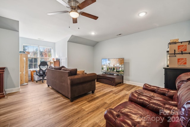 living room with light wood-type flooring, vaulted ceiling, and ceiling fan