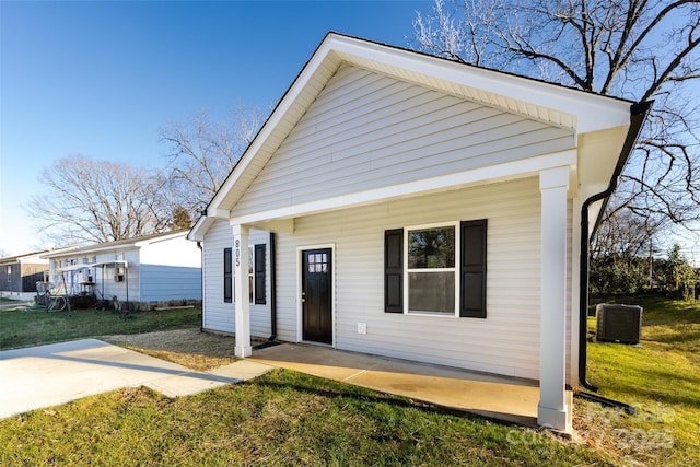 view of front of property featuring a front yard and central AC