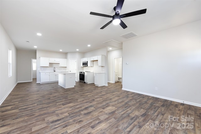 unfurnished living room featuring dark hardwood / wood-style floors, ceiling fan, and sink