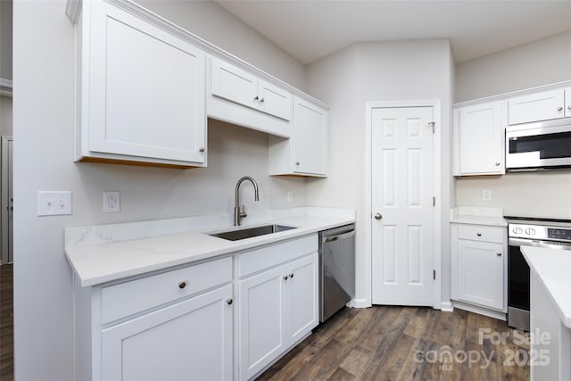 kitchen featuring appliances with stainless steel finishes, dark hardwood / wood-style flooring, white cabinetry, and sink