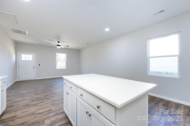 kitchen featuring a center island, dark hardwood / wood-style floors, white cabinetry, and ceiling fan